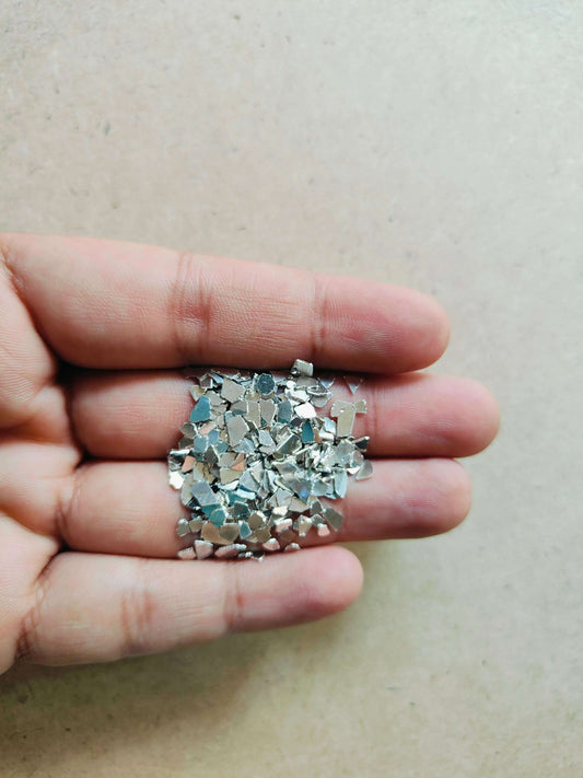 Hand holding silver crystal chips for resin art showcasing sparkling details for craft projects