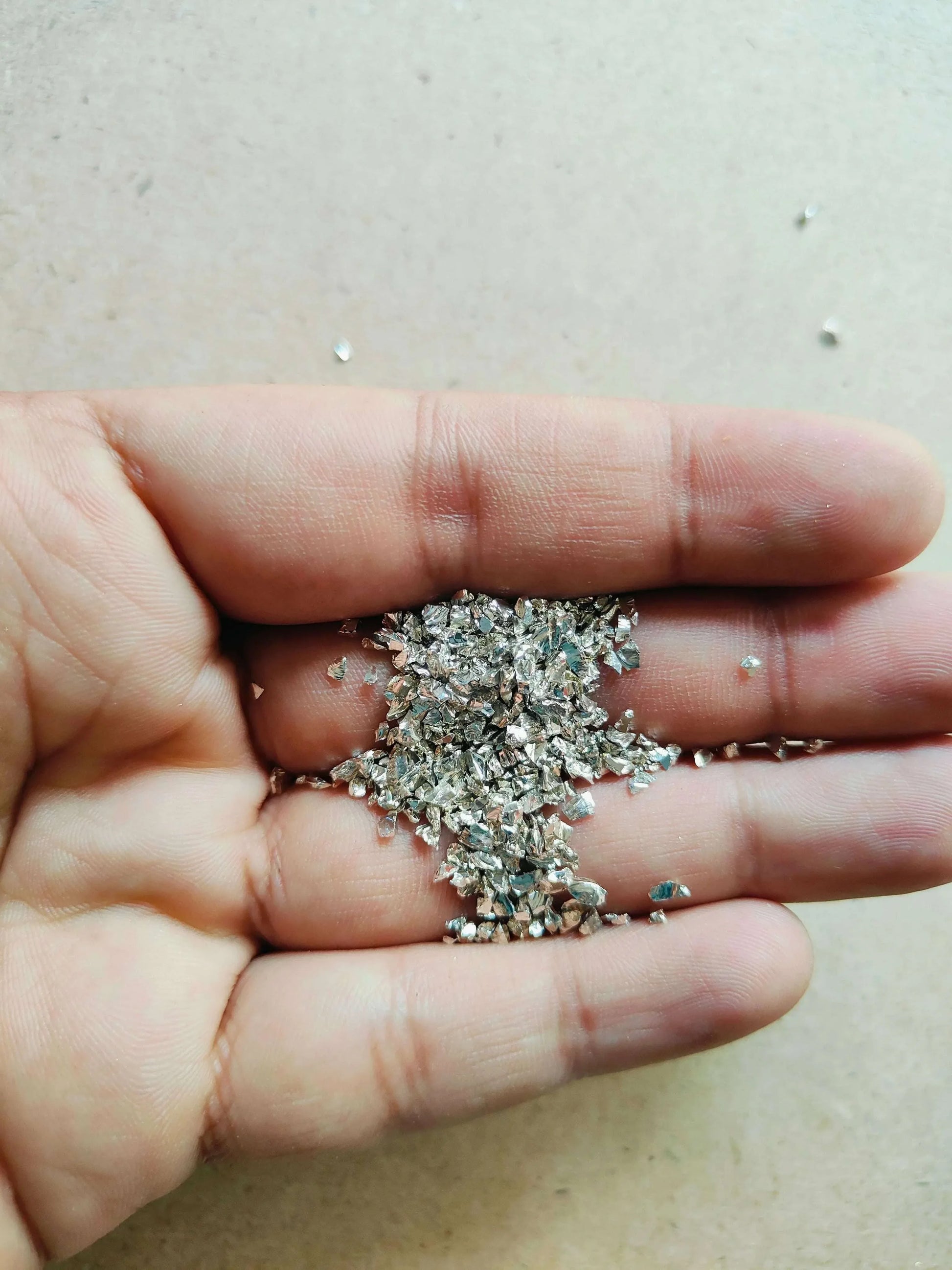 Granules Silver Stones, handful of glittering silver stones in open palm