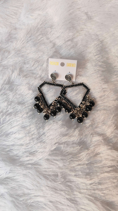 silver-jhumka-earrings-with-beads-black-on-fur-background
