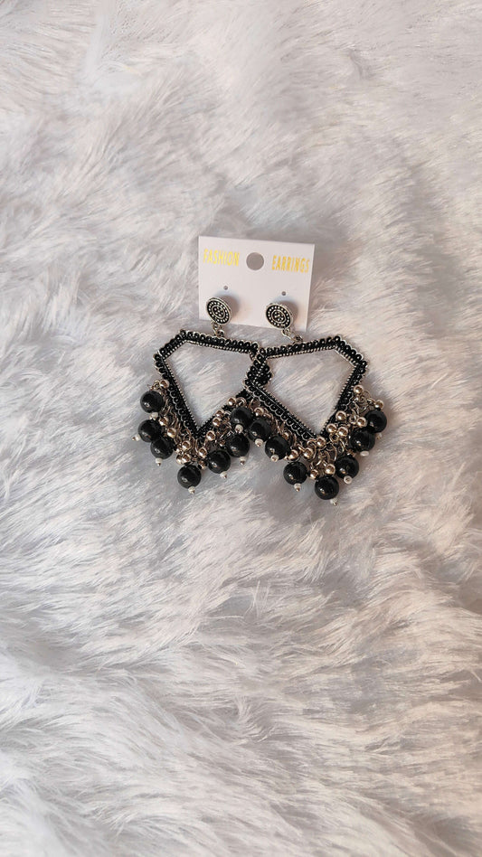 silver-jhumka-earrings-with-beads-black-on-fur-background