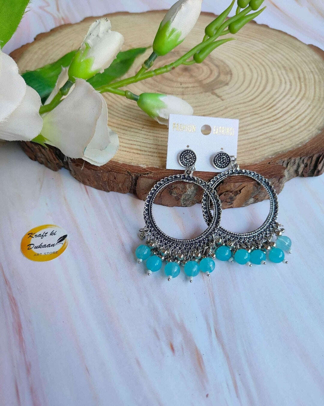 Silver round jhumka with dangling beads, turquoise/light-blue bead fringe.