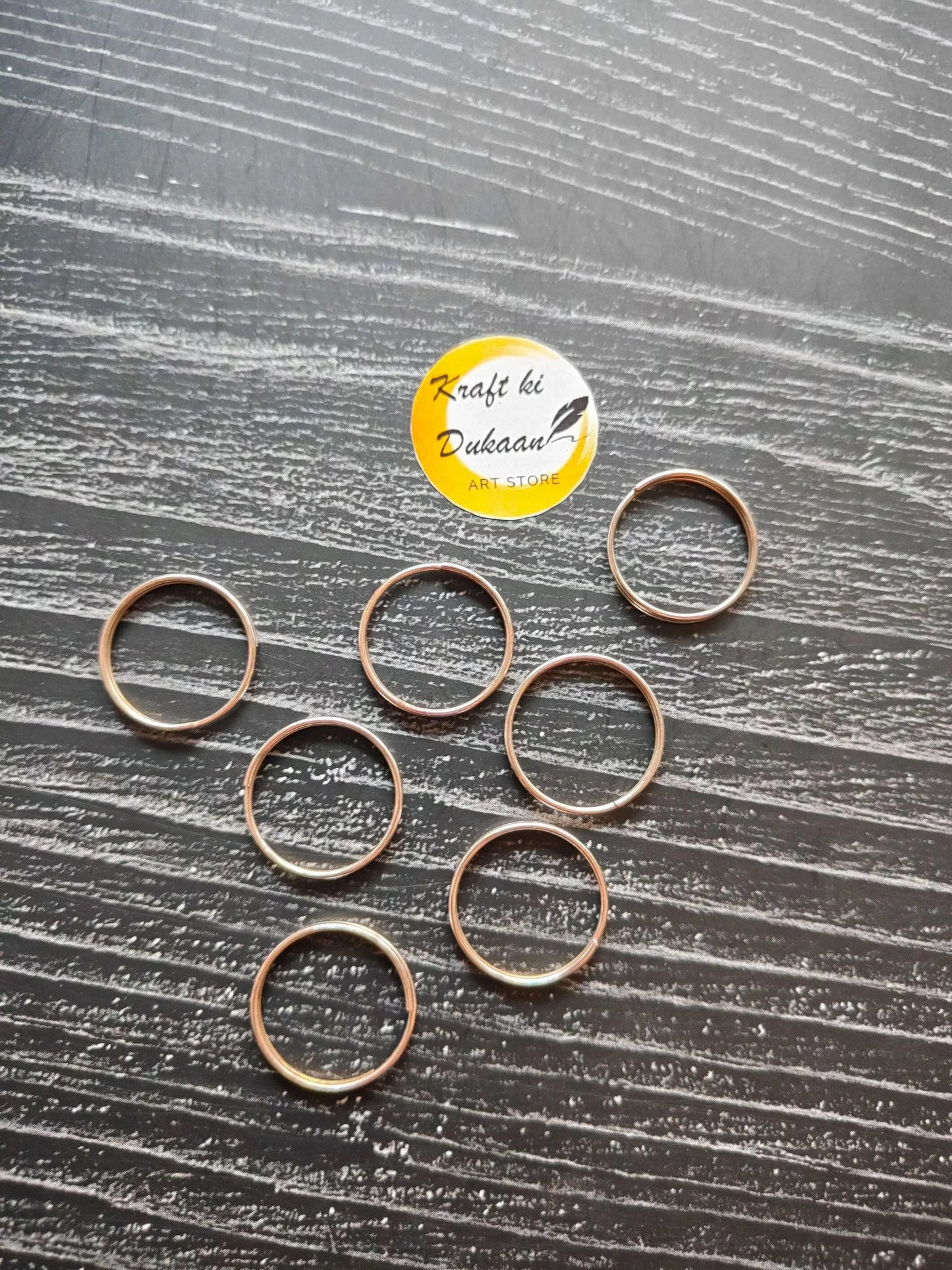Gold-toned circle metal rings with open loop shape, shown together.