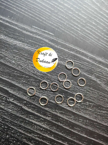 Small silver-tone ring loops in a loose cluster on a flat surface.