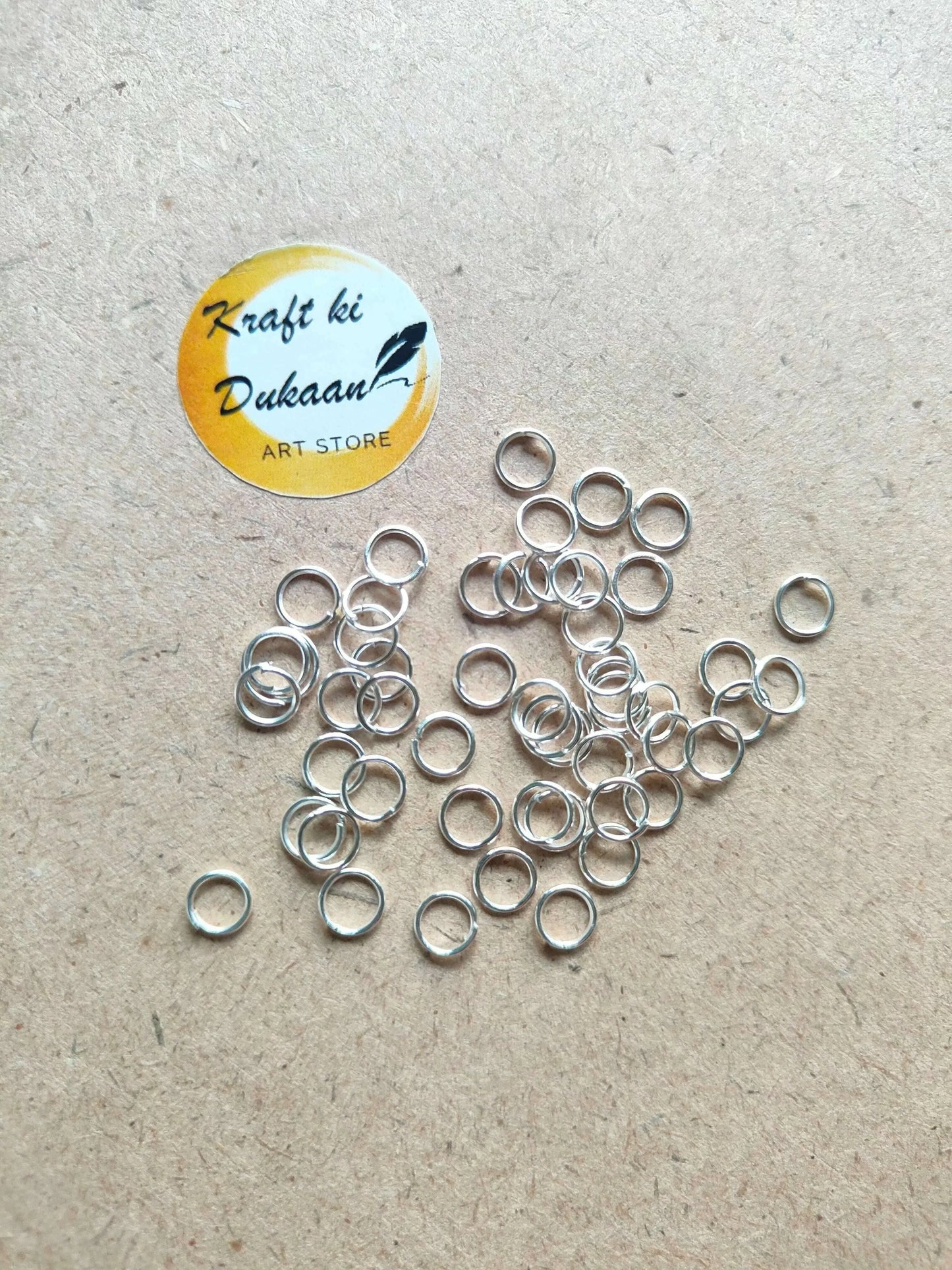 Silver-tone metal circle rings, mixed open loops spread on a light surface.