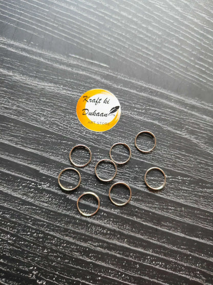Silver circle metal rings, open loop style, arranged in a scattered group.