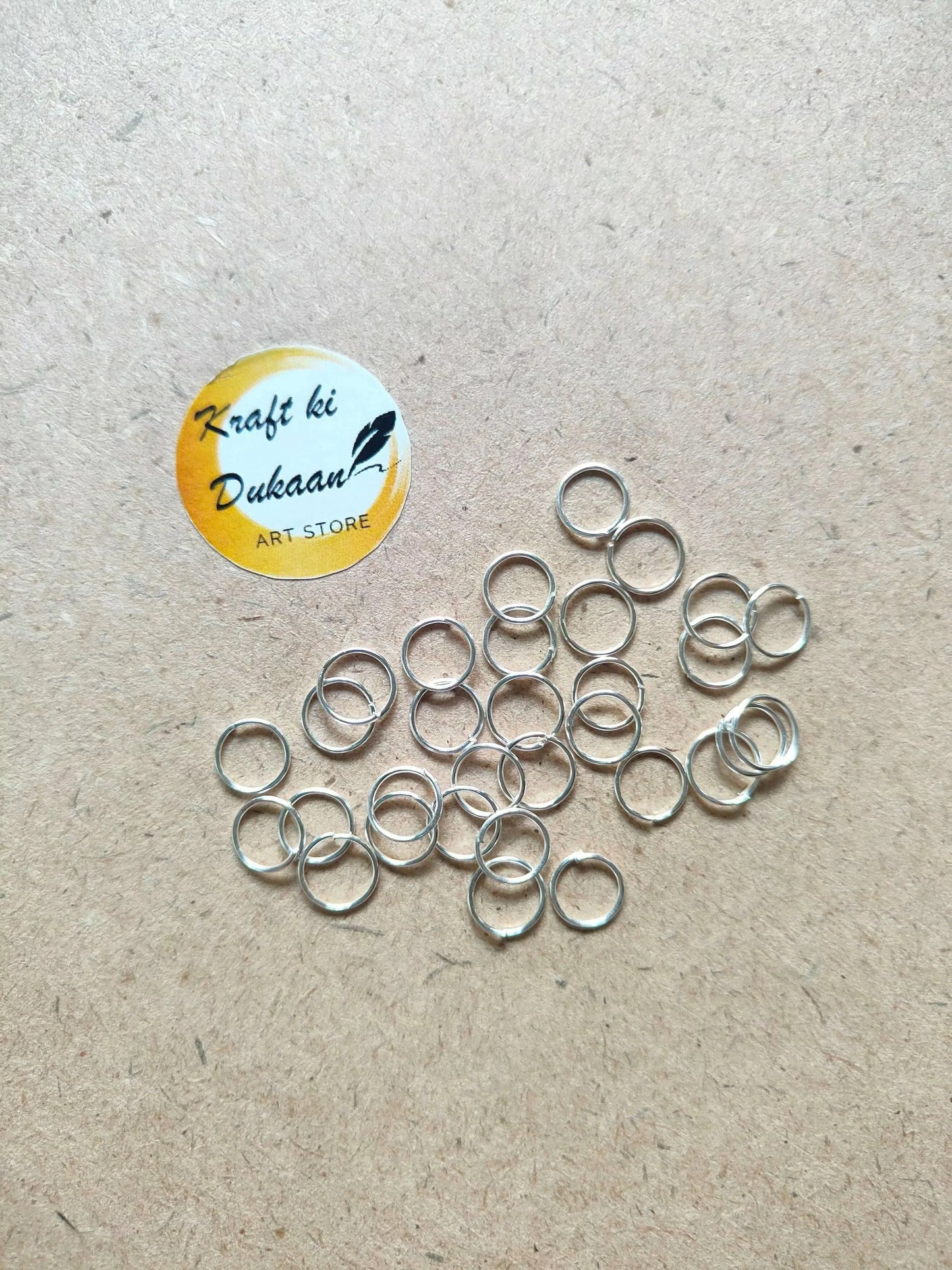 Silver-tone circle metal rings, scattered open loops with varied ring sizes.