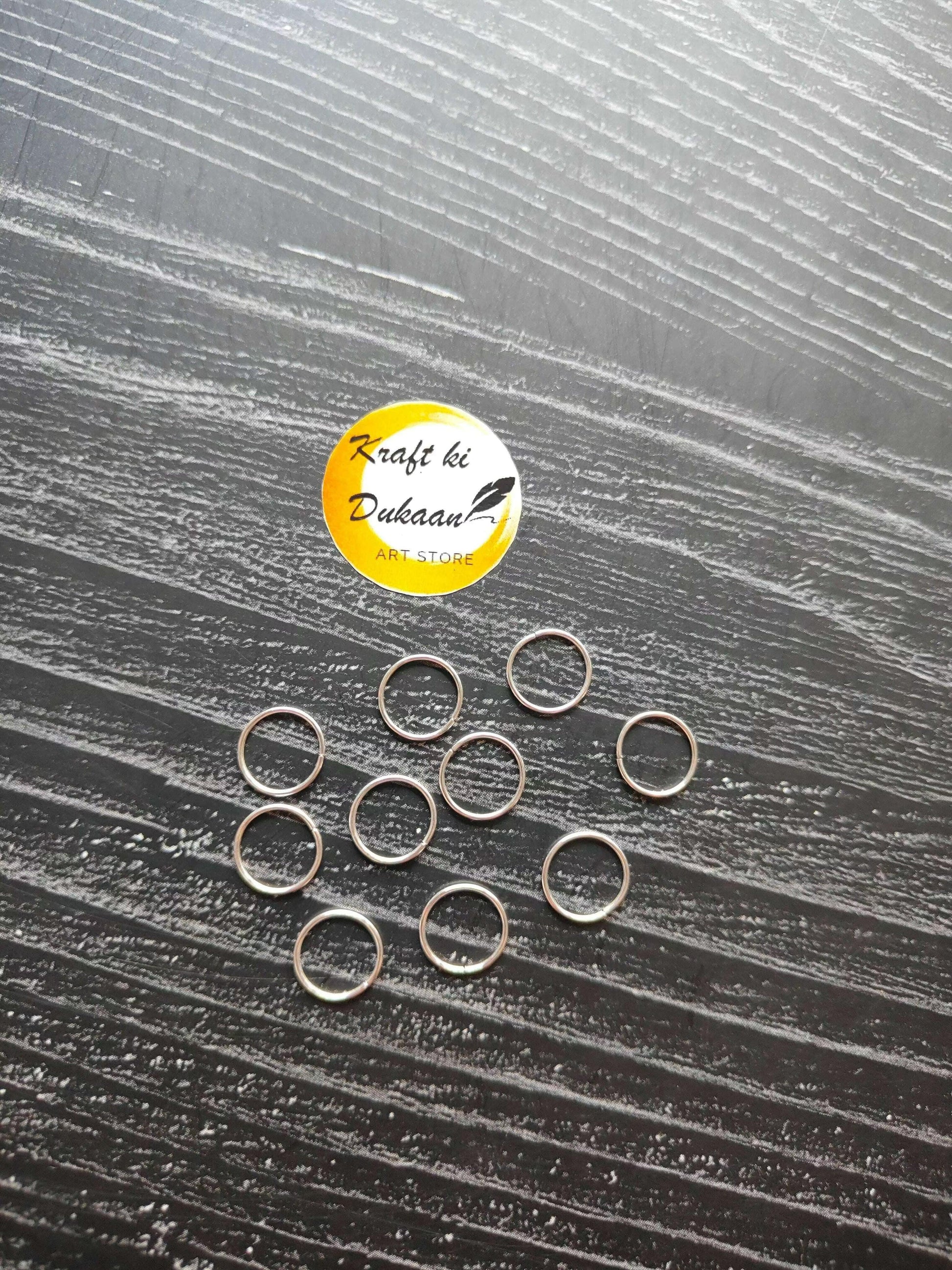 Silver-tone open circle metal rings, multiple pieces laid out in rows.