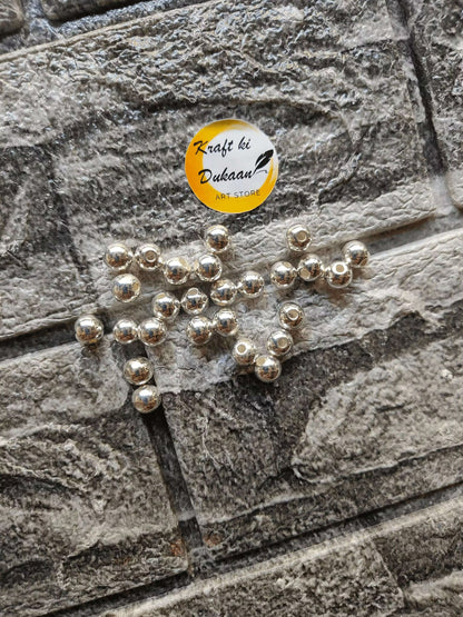 silver-pearl-beads-for-jewelry-making-scattered-on-wall