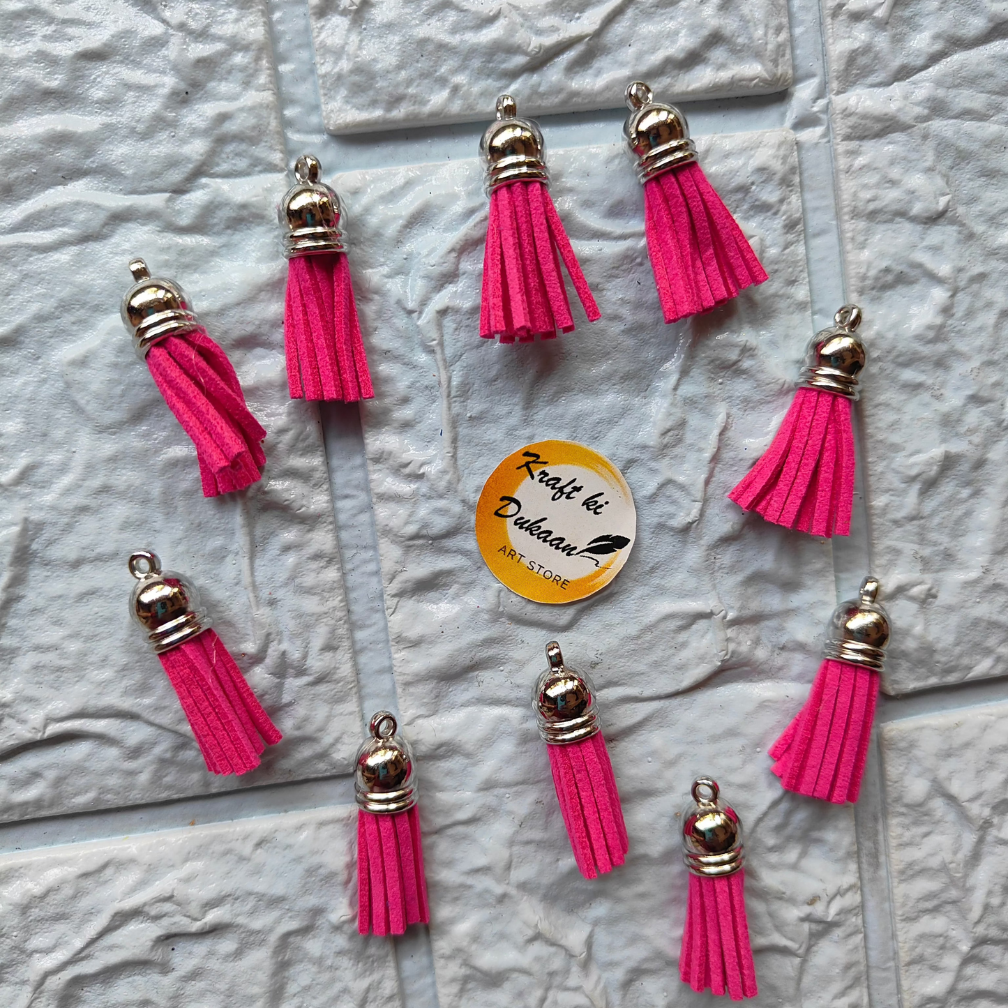 Set of pink leather tassel charms with silver accents from Kraft ki Dukaan, perfect for DIY crafts