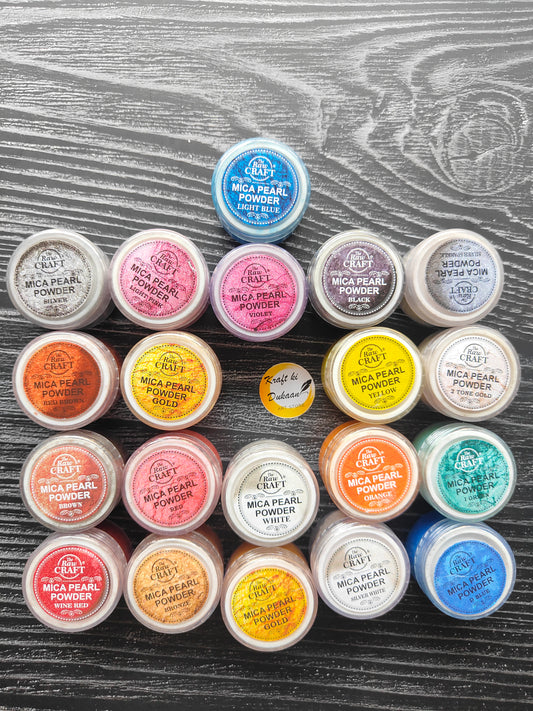 Variety of vibrant MICA pearl powder for resin in different colors in plastic containers arranged on a wooden background