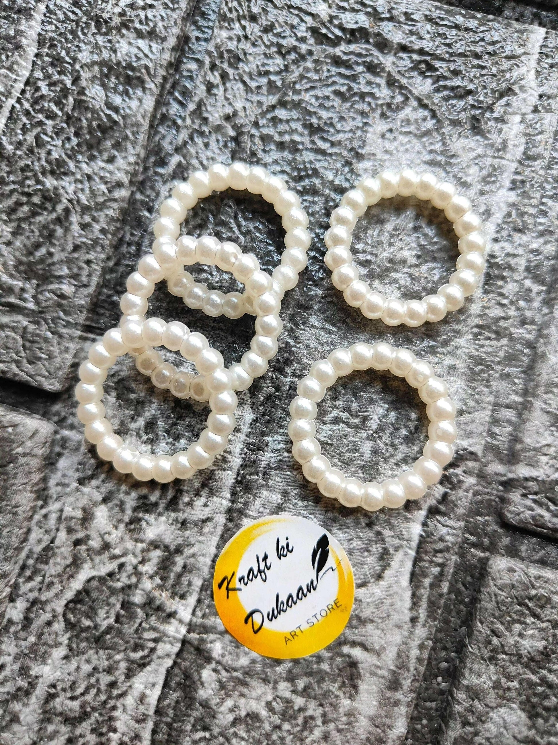 White pearl bead rings with chunky bead band, close-up of 4 rings