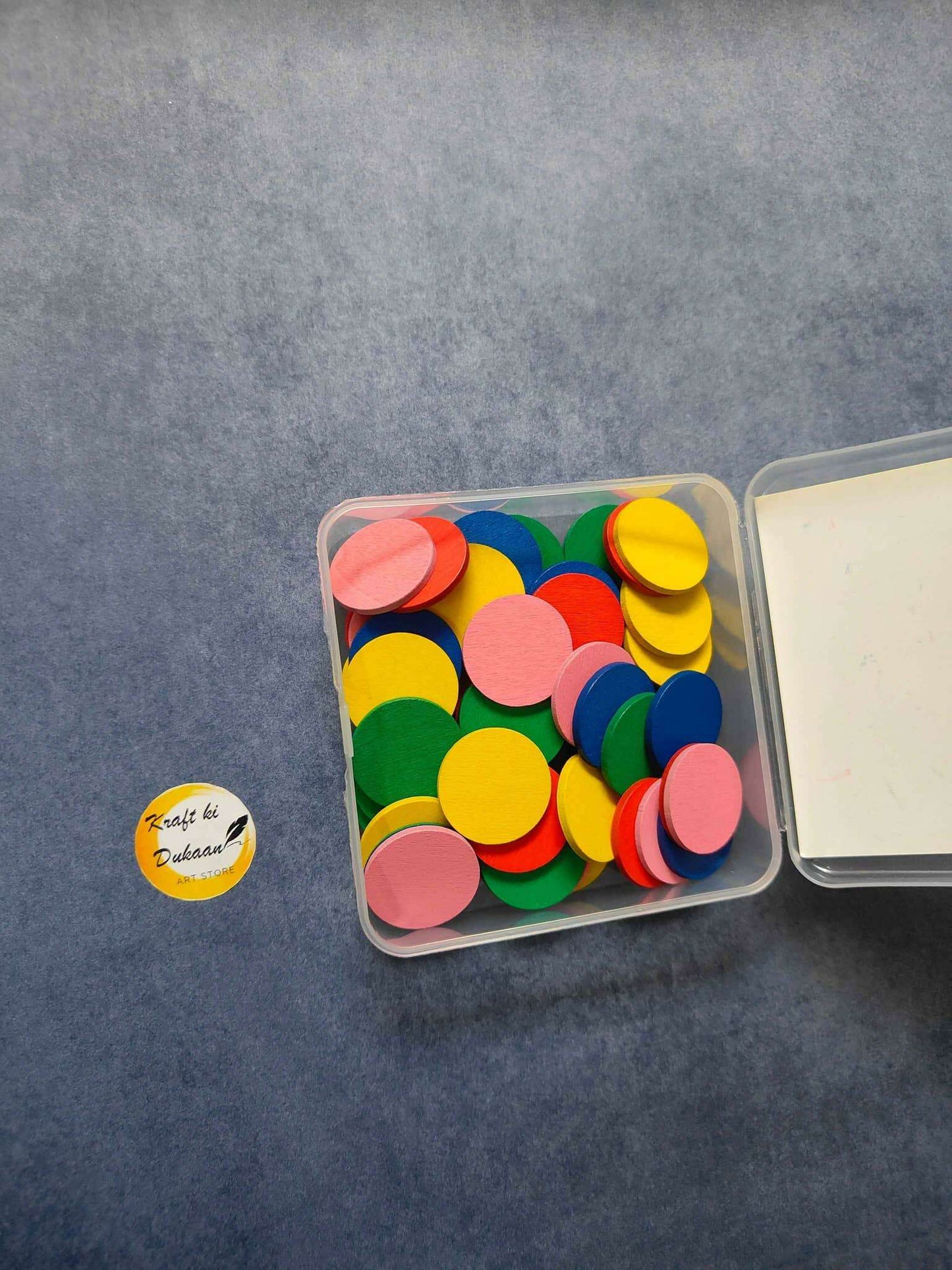 Craft wood coin set with multicolor wooden coins in clear box; lid partly open